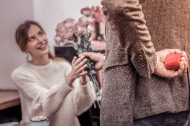 Erkek kadına çiçek hediye ediyor. Evlenme teklif etmek üzere