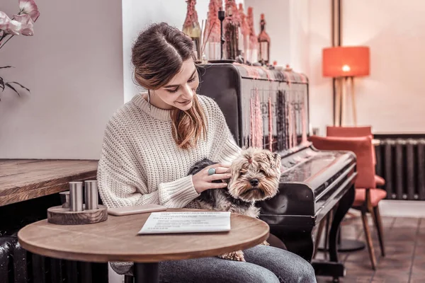 Egy mosolygó nő a kutyájával a kávézóban. — Stock Fotó