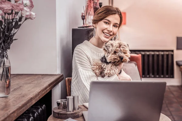 Sonriente hermosa mujer trabajando en el ordenador portátil con su mascota — Foto de Stock