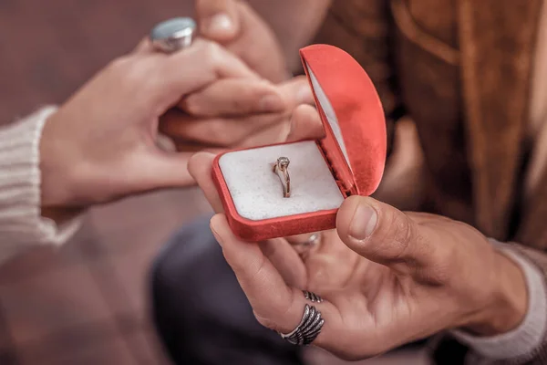 Vista superior cercana de una mano de mujer y mano de hombre que sostiene la caja del anillo esperando una respuesta — Foto de Stock