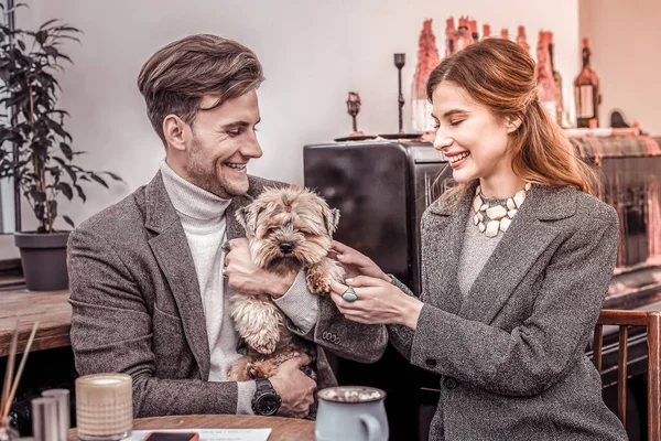 Портрет счастливой пары, сидящей в кафе с собакой — стоковое фото