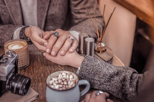 Photo of man and woman holding hands on table — Stock Photo, Image