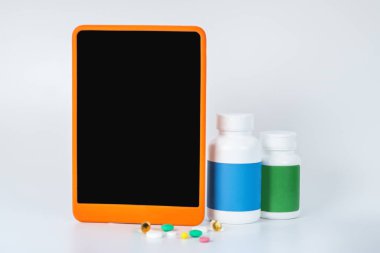 Akıllı telefonun yanında üç şişe takviye var.