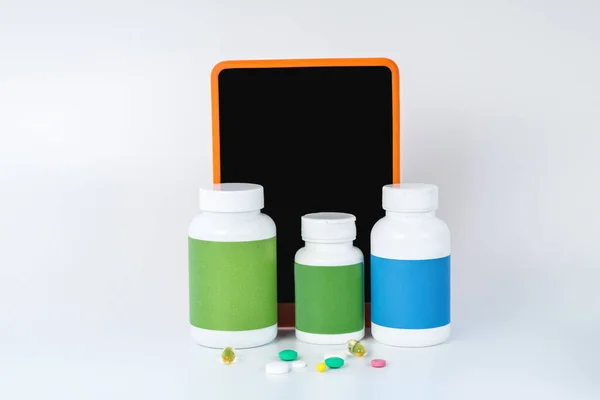 Three bottles of medicla supplements next to the smartphone — Stock Photo, Image