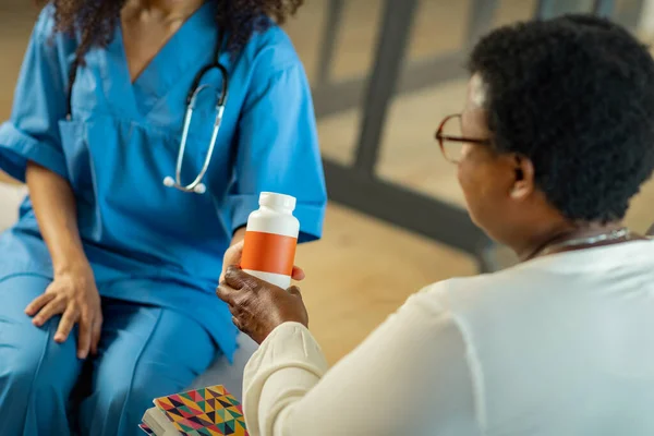 Nice aged woman taking the medicine from her nurse — Stock Photo, Image