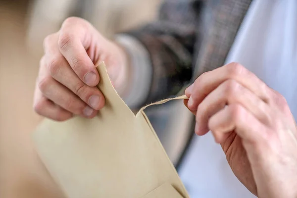 Close up picture of mans hands opening the envelope — Stock Photo, Image