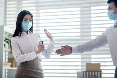 Koruyucu maskeli bir adam elini uzatıyor.