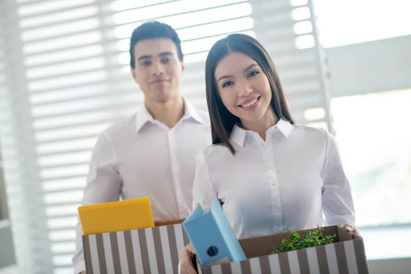 Twee collega 's die dozen met kantoorspullen vasthouden en er gelukkig uitzien — Stockfoto