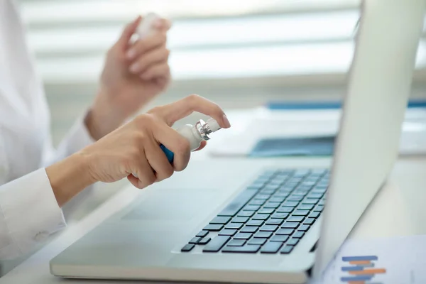 Weibliche Hände halten Desinfektionsmittel in der Hand und sprühen es in die Oberfläche — Stockfoto