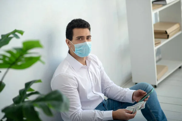 Hombre sentado en el suelo y mirando preocupado — Foto de Stock