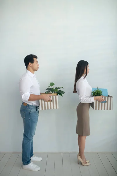Muž a žena stojí u zdi s krabicemi v rukou — Stock fotografie