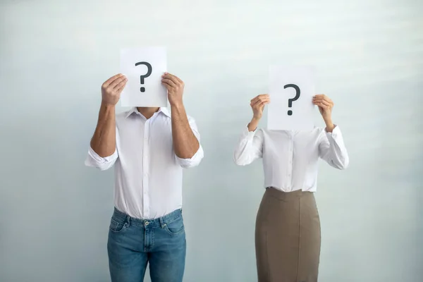 Man and woman standing next close to each other holding question signs — Stock Photo, Image