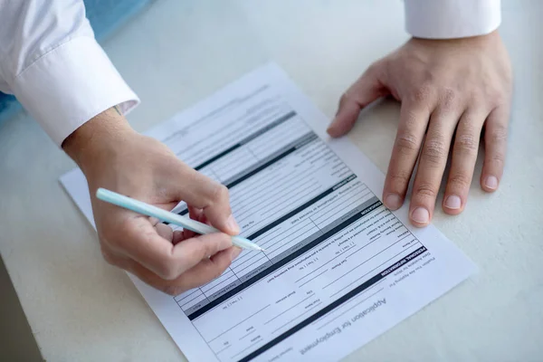 Close up of a man signing the unemployment application — Stock Photo, Image