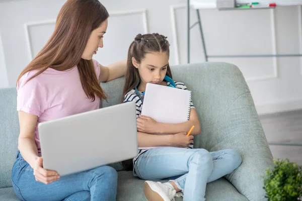 Verveeld dochter en zorgzame Moeder met een laptop. — Stockfoto
