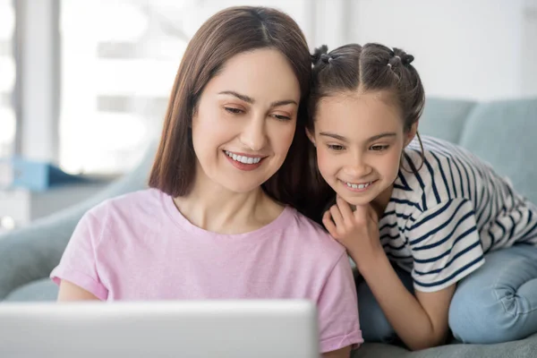 Ευτυχισμένη και όμορφη μητέρα με κόρη κοιτάζοντας το laptop. — Φωτογραφία Αρχείου