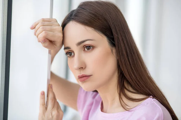 Droevige eenzame vrouw die uit het raam kijkt. — Stockfoto