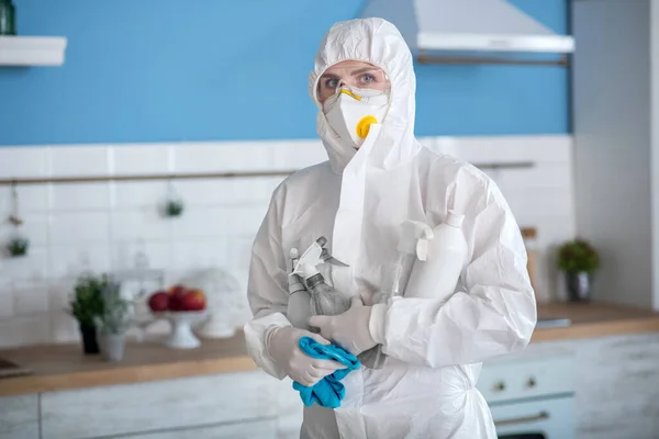 Donna in abiti da lavoro bianchi e guanti con un disinfettante — Foto Stock