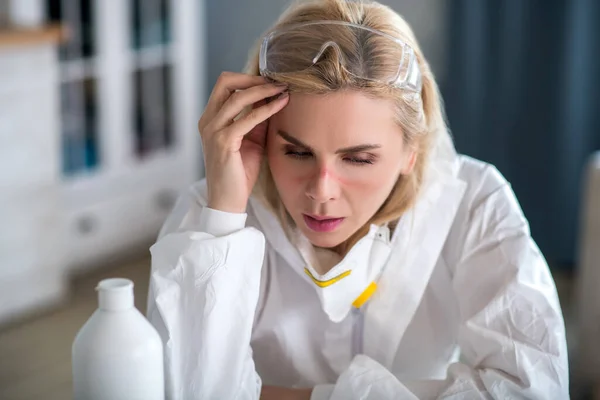 Femme blonde en vêtements de travail blancs se reposant après la désinfection de l'appartement — Photo