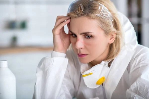 Mujer rubia en ropa de trabajo blanca buscando cansado —  Fotos de Stock