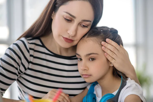 Joven madre abrazando triste hija detrás de la cabeza . — Foto de Stock