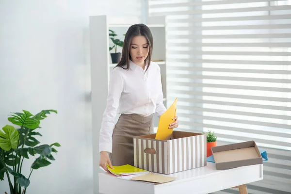 Joven morena mujer poniendo sus cosas personales en la caja — Foto de Stock