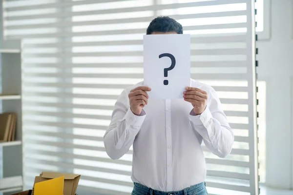 Junger Mann hält Schild mit Fragezeichen — Stockfoto