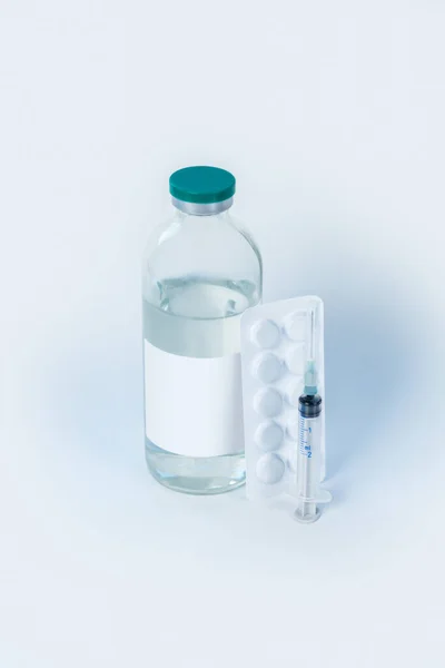 Бутылка стерильной жидкости с сиропом и таблетками — стоковое фото