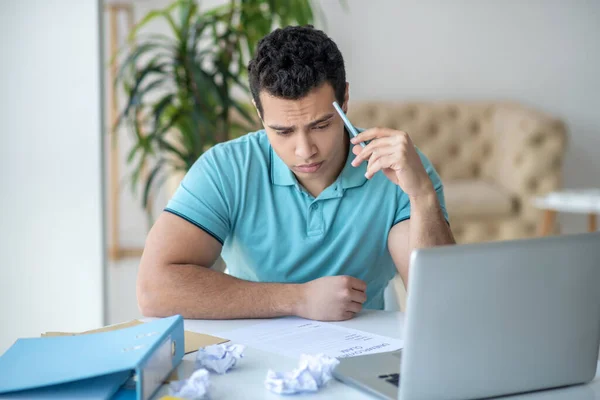 Upset dark-haired male sitting at his desk, filling in unemployment claim — Stock Photo, Image