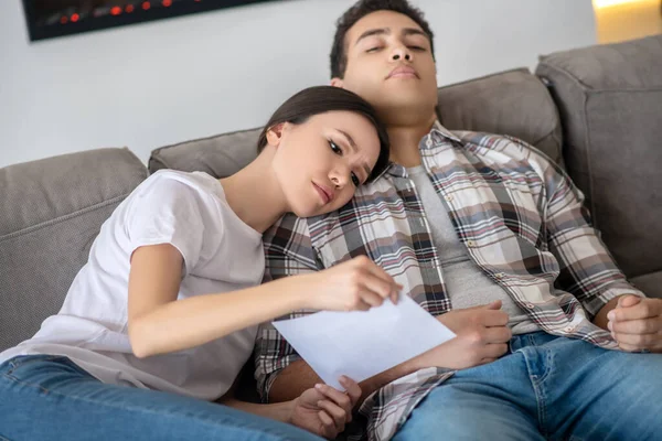 Mujer morena sosteniendo papel, apoyando la cabeza sobre el hombro moreno masculino — Foto de Stock