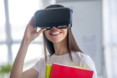 Siyah saçlı, kulaklık takan ve memnun hisseden bir kız.