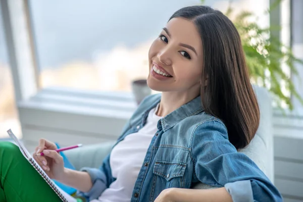 Young woman in a jeans jacket smiling beautifully — Stock Photo, Image