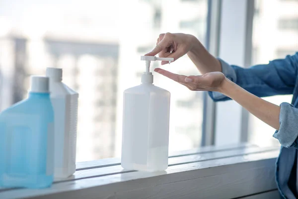 Imagen de cerca de las manos de las mujeres apretando antiséptico — Foto de Stock