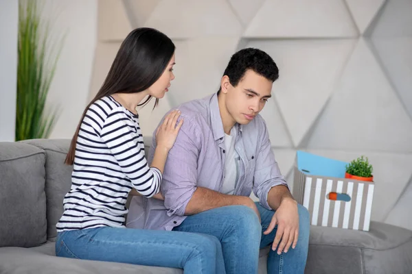 Jovem casal sentado em casa no sofá . — Fotografia de Stock