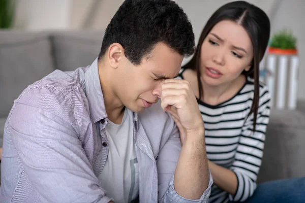 Joven con los ojos cerrados y mujer simpática . — Foto de Stock