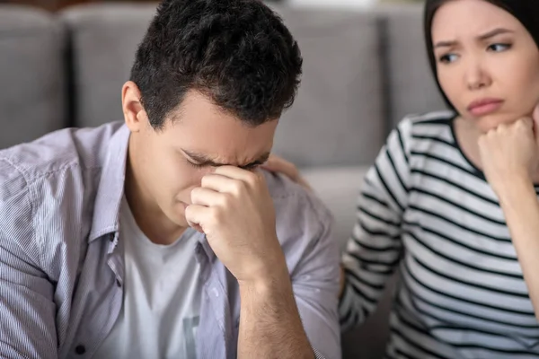 Tipo infeliz cerrando los ojos y esposa preocupada . — Foto de Stock