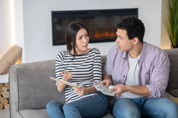 Young husband and wife talking seriously on the couch. — Stock Photo, Image