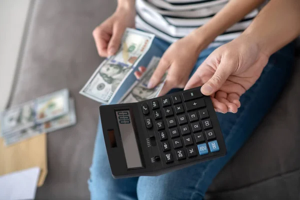 Main masculine avec une calculatrice mains féminines avec de l'argent . — Photo