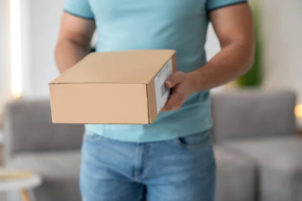Young male hands holding brown cardboard box — Stock Photo, Image