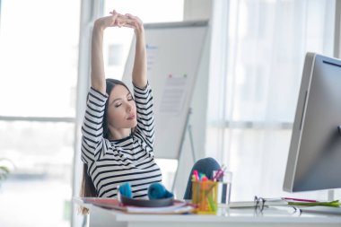 Güzel esmer kadın iş gününden sonra geriniyor.