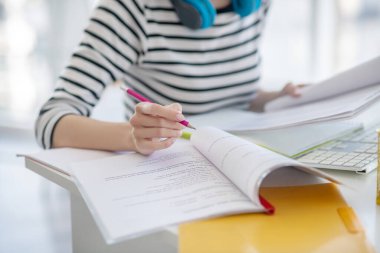 Çizgili tişörtlü kadın kağıtlarla çalışıyor.