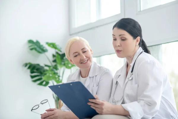 Två kvinnliga läkare läser receptlistan — Stockfoto