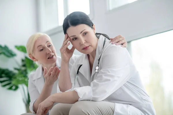 Morena médico olhando frustrado, seu colega olhando preocupado — Fotografia de Stock