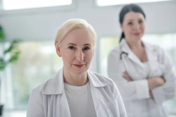 Два врача в белых халатах выглядят решительными — стоковое фото
