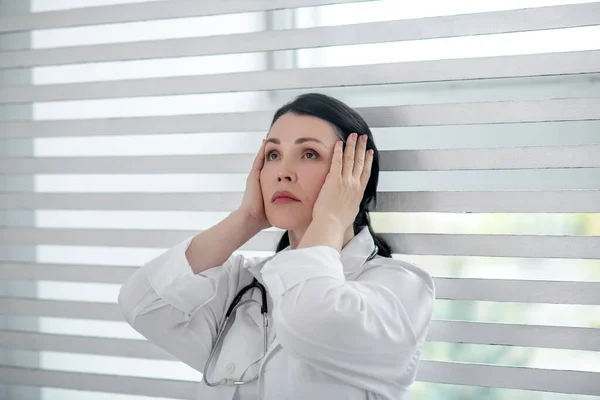 Donna in un cappotto medico bianco guardando in alto . — Foto Stock