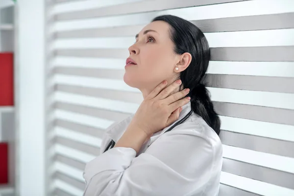 Woman with a stethoscope standing back to the window. — Stock Photo, Image