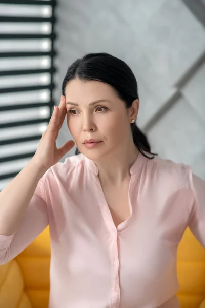 Beautiful adult woman in a pink blouse looking aside. — Stock Photo, Image