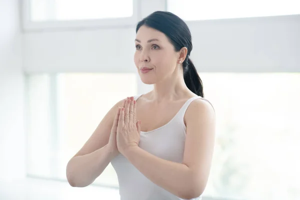 Brunett kvinna utför namaste, trycka händerna tillsammans — Stockfoto