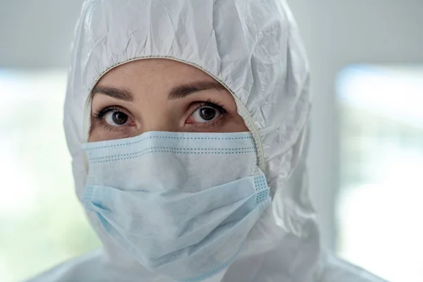Detailní záběr pracovnice v ochranném oděvu a lékařské masce — Stock fotografie