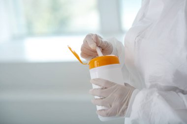 Tıbbi işçilerin yakın çekimleri, dezenfekte şişesini tutan, bir tanesini çıkartan