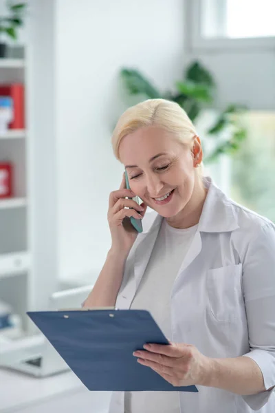 Blondynka lekarz o odległej konsultacji telefonicznej — Zdjęcie stockowe